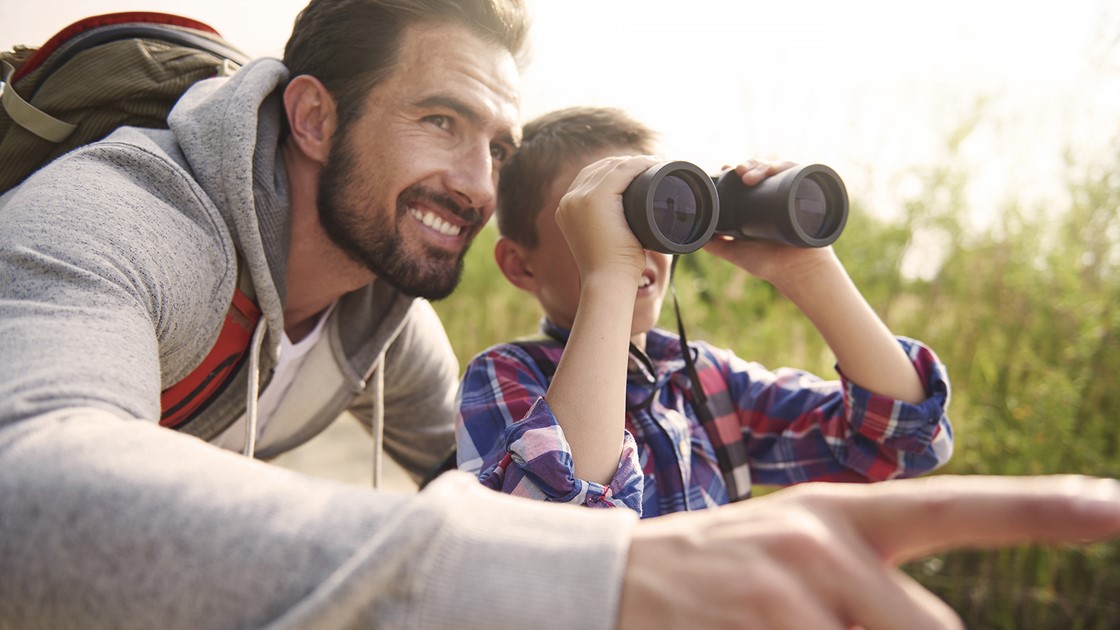 Deposits for children future - Father and boy with binoculars outdoors